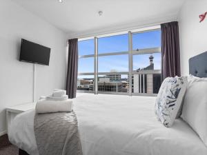 a bedroom with a large bed and a large window at Central City 1BR Apartment in Auckland