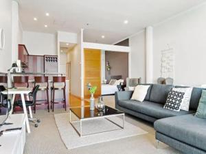 a living room with a couch and a table at Relaxing Sea Wharf View Apartment in Auckland