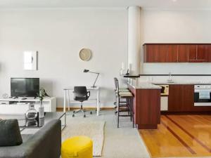 a living room with a couch and a kitchen at Relaxing Sea Wharf View Apartment in Auckland