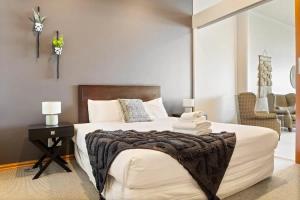 a bedroom with a large white bed and a table at Relaxing Sea Wharf View Apartment in Auckland