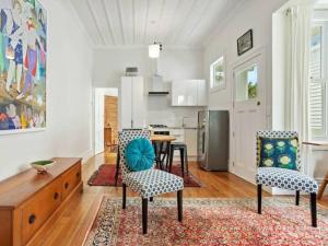 un soggiorno con tavolo e sedie e una cucina di Cheerful 1 Bedroom Home with Free Parking ad Auckland