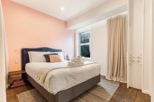 Un dormitorio con una cama grande y una ventana en Awesome Apartment w Parking, en Auckland