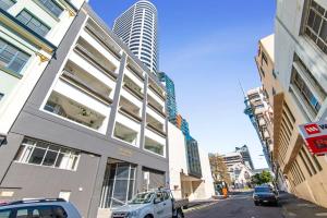 un edificio en una calle con coches aparcados delante en Cosy and central studio, en Auckland