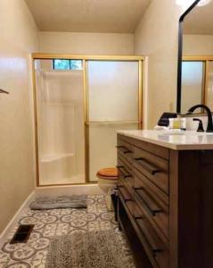 a bathroom with a shower and a toilet and a sink at Treehouse Cottage in Crestline +14 photos