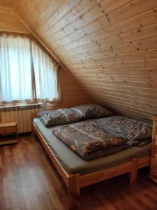 a bed in a room with a wooden ceiling at W Cisnej pod 1. in Cisna