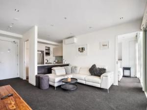 a living room with a couch and a table at Stunning Views of Viaduct Harbour Free Parking in Auckland