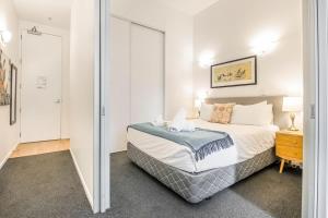 - une chambre avec un grand lit et un miroir dans l'établissement Open-plan living in the heart of Auckland, à Auckland