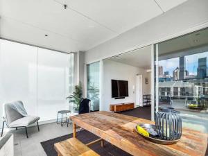 a living room with a wooden table and a pool at Stunning Views of Viaduct Harbour Free Parking in Auckland