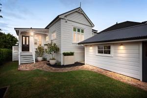 a white house with a garage and a yard at Three-Bedroom Grey Lynn Villa in Auckland