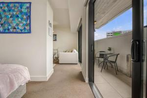 Habitación con balcón, cama y mesa. en Bright & modern 1BR in Auckland CBD by Zodiak Stays, en Auckland