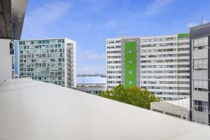 una vista de dos edificios altos con una señal verde en Bright & modern Auckland CBD apartment, en Auckland