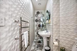 La salle de bains blanche est pourvue d'un lavabo et de toilettes. dans l'établissement Stylish Central Penthouse, à Auckland