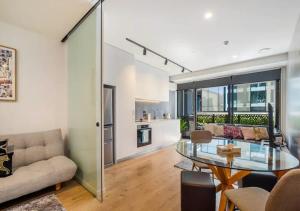 uma sala de estar com uma mesa de vidro e um sofá em Classy and contemporary living em Auckland