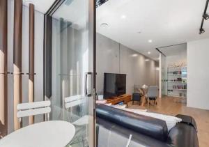 uma sala de estar com um sofá e uma televisão em Classy and contemporary living em Auckland