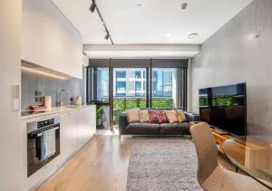 uma sala de estar com um sofá e uma mesa em Classy and contemporary living em Auckland