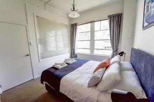 um quarto com uma cama com almofadas e uma janela em Central Auckland 1-bedroom apartment em Auckland