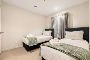 a bedroom with two beds and a window at Spacious Mount Eden Apartment in Auckland