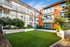 an apartment with a lawn in front of a building at Spacious Mount Eden Apartment in Auckland