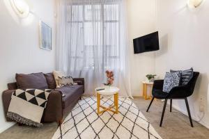 a living room with a couch and a table at Cosy Queen St 1-BR apartment in Auckland