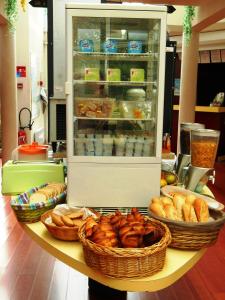 a counter with a refrigerator and baskets of food at Good Night Hotel in Arques