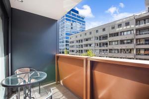 a balcony with a table and chairs and a building at Sleek central apartment with a private balcony in Auckland