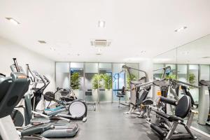 a gym with cardio machines and treadmills at Sleek central apartment with a private balcony in Auckland