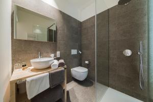 bagno con lavandino e doccia in vetro di Zum Hirschen Boutique Hotel Val di Non a Senale-San Felice