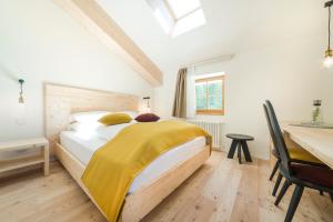 Un dormitorio con una cama con una manta amarilla. en Zum Hirschen Boutique Hotel Val di Non, en Unsere Liebe Frau im Walde