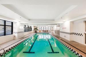 an indoor swimming pool with a large pool at City views from 1BR Queen St apartment in Auckland