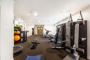 a gym with treadmills and machines in a room at City views from 1BR Queen St apartment in Auckland