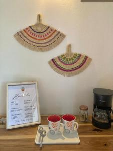 a table with two cups and a plate with a coffee maker at Casa Yami Lodge in Fortuna +9 photos
