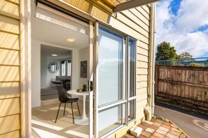 una puerta corredera de cristal que da a un balcón con mesa en Stunning studio in Grey Lynn, en Auckland