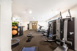 a gym with treadmills and machines in a room at Cosy studio on Queen Street in Auckland
