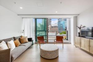 a living room with a couch and a large window at Urban Escape: Prime Location in Auckland