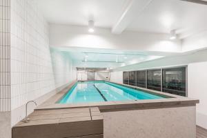a large swimming pool in a building at Urban Escape: Prime Location in Auckland