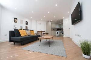ein Wohnzimmer mit einem Sofa und einem Tisch in der Unterkunft Spacious 1 Bed with free parking in Hounslow in Hounslow