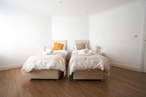 ハウンズローにあるSpacious 1 Bed with free parking in Hounslowのベッド2台が隣同士に設置された部屋です。