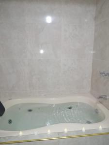 eine weiße Badewanne im Bad mit Dusche in der Unterkunft Inca´s Suite in Los Baños del Inca
