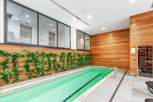 a swimming pool with plants on the wall at Vibrant Minimalism - City Views in Auckland