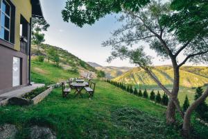 une table et des chaises sur une colline herbeuse avec vue dans l'établissement Relaxing holiday house, à Sarajevo