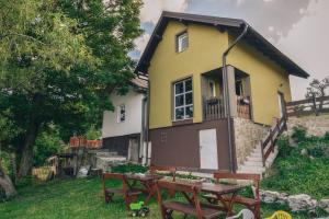 ein gelbes Haus mit einem Picknicktisch davor in der Unterkunft Relaxing holiday house in Sarajevo + 13 Fotos
