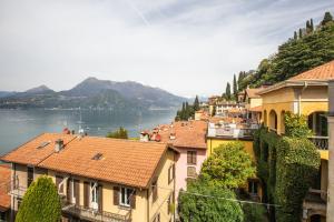 um grupo de edifícios com vista para a água em Albergo Del Sole em Varenna