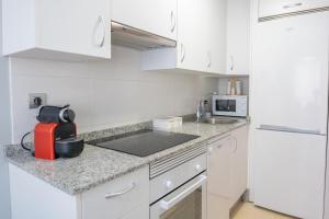 a kitchen with white cabinets and a red appliance at VIGO CENTRO in Vigo