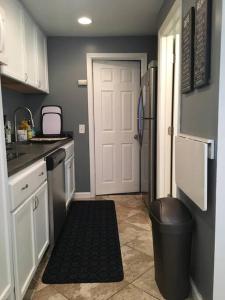 a kitchen with a white door and a trash can at The Barker Cottage in Omaha