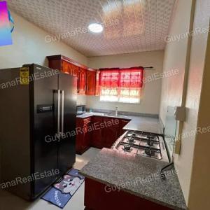 a kitchen with a refrigerator and a stove at S&S Guyana Real Estate Apartment in Georgetown