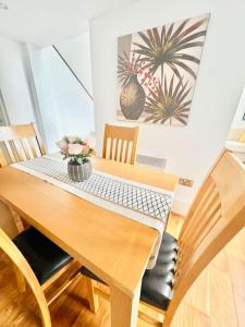 tavolo da pranzo con sedie e vaso di fiori di Double height ceiling spacious city apartment a Sheffield