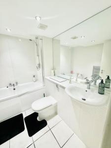 bagno bianco con servizi igienici e lavandino di Double height ceiling spacious city apartment a Sheffield