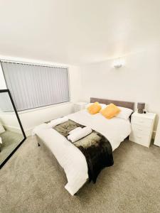 una camera da letto con un letto con due cuscini e una finestra di Double height ceiling spacious city apartment a Sheffield