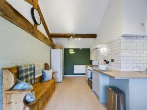 a kitchen with a wooden bench in a room at Rosina Barn in Boddicott
