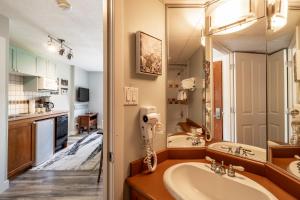 Un baño con lavabo y un espejo grande. en Cascade by Elevate Vacations, en Whistler